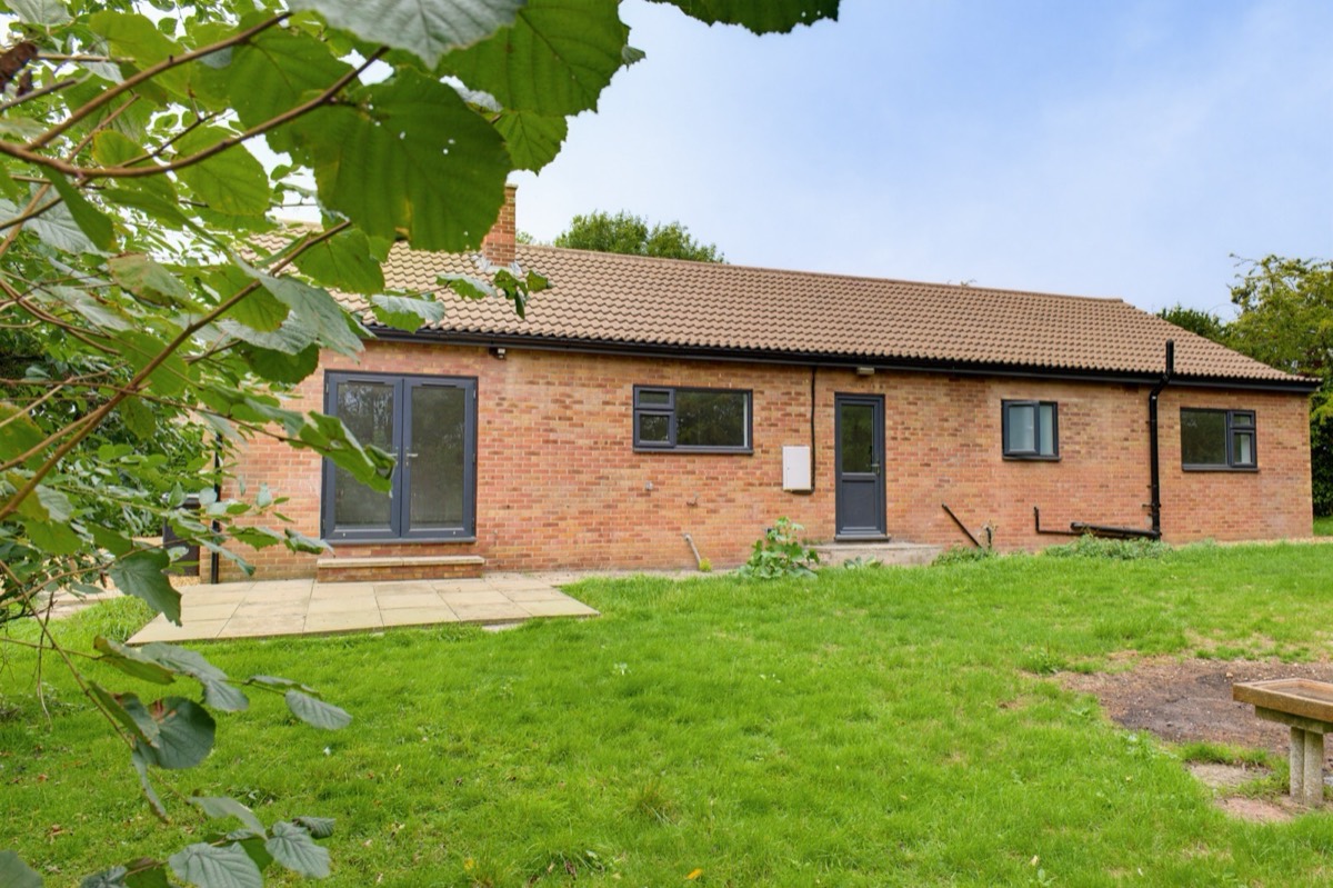 Red brick bungalow rear elevation with French doors onto the garden
