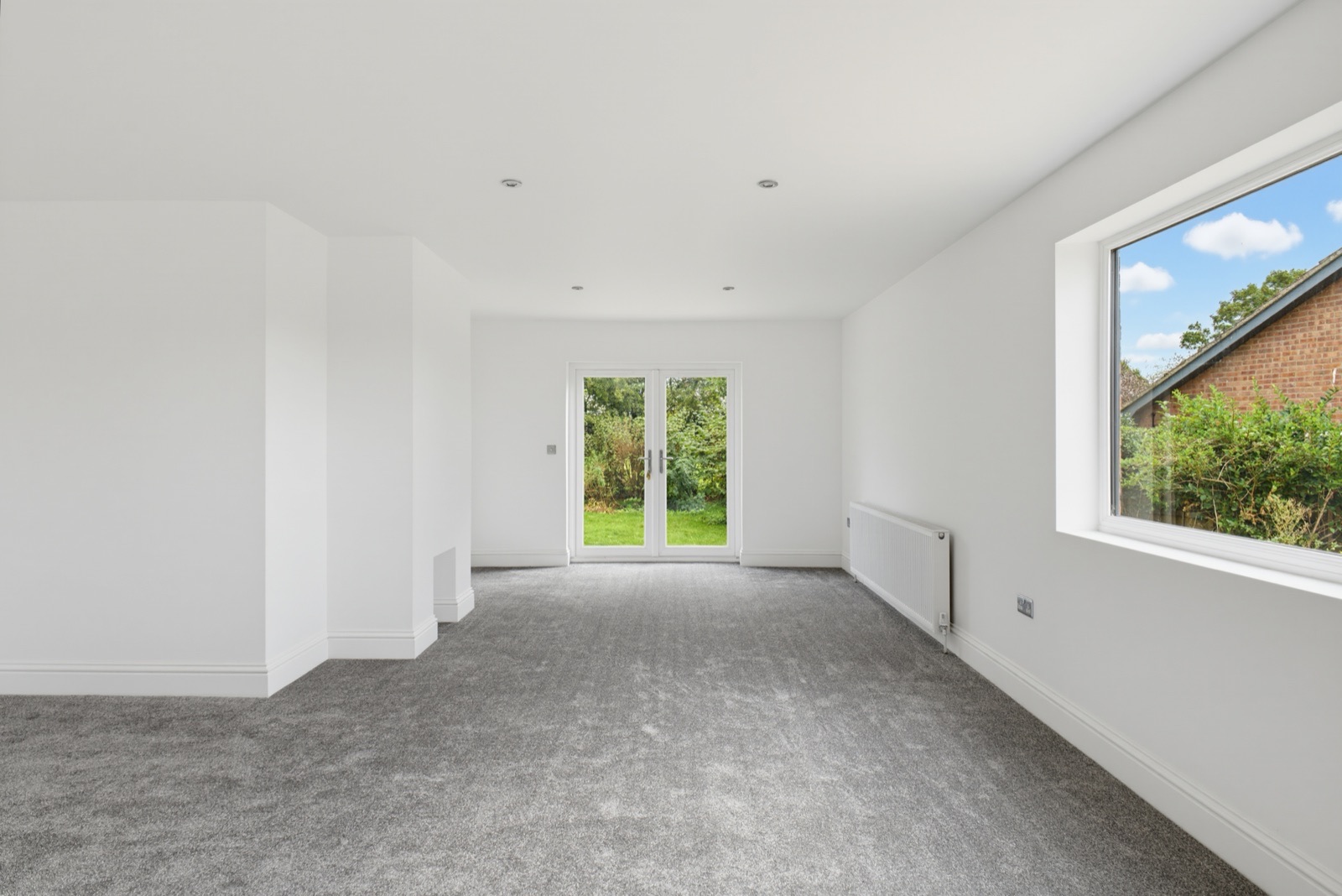 Unfurnished reception room with French doors and a large window