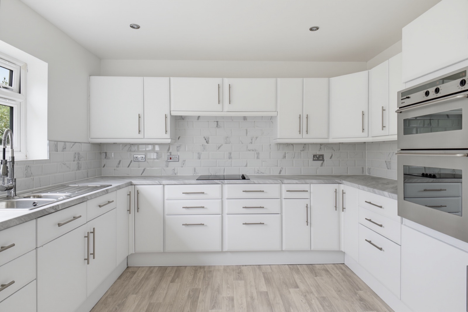 Modern white fitted kitchen with integrated double oven